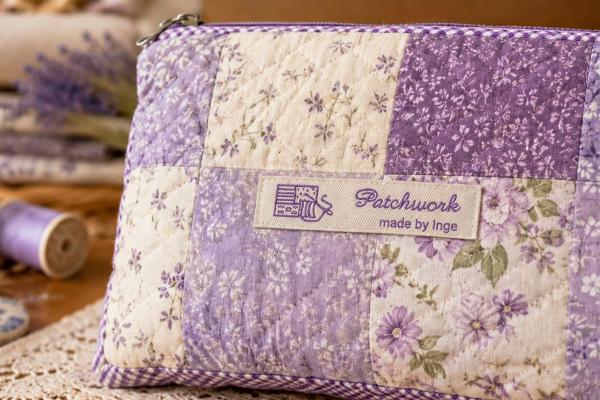 Etichetta in cotone naturale con scritta lilla su borsa patchwork