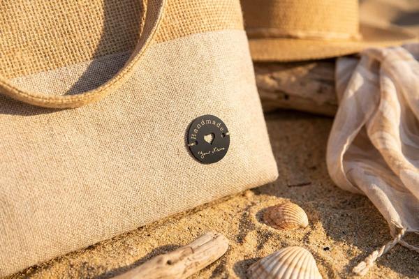 Etichetta rotonda in acciaio su borsa di juta con cuore traforato